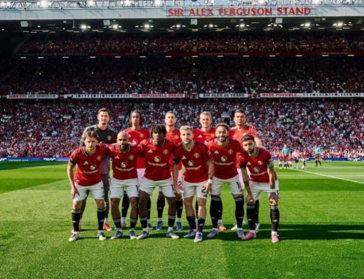 Macnhested United players take a photo with the crowd at Old Trafford in the background before their first match in the Premier League 2025-26 season.