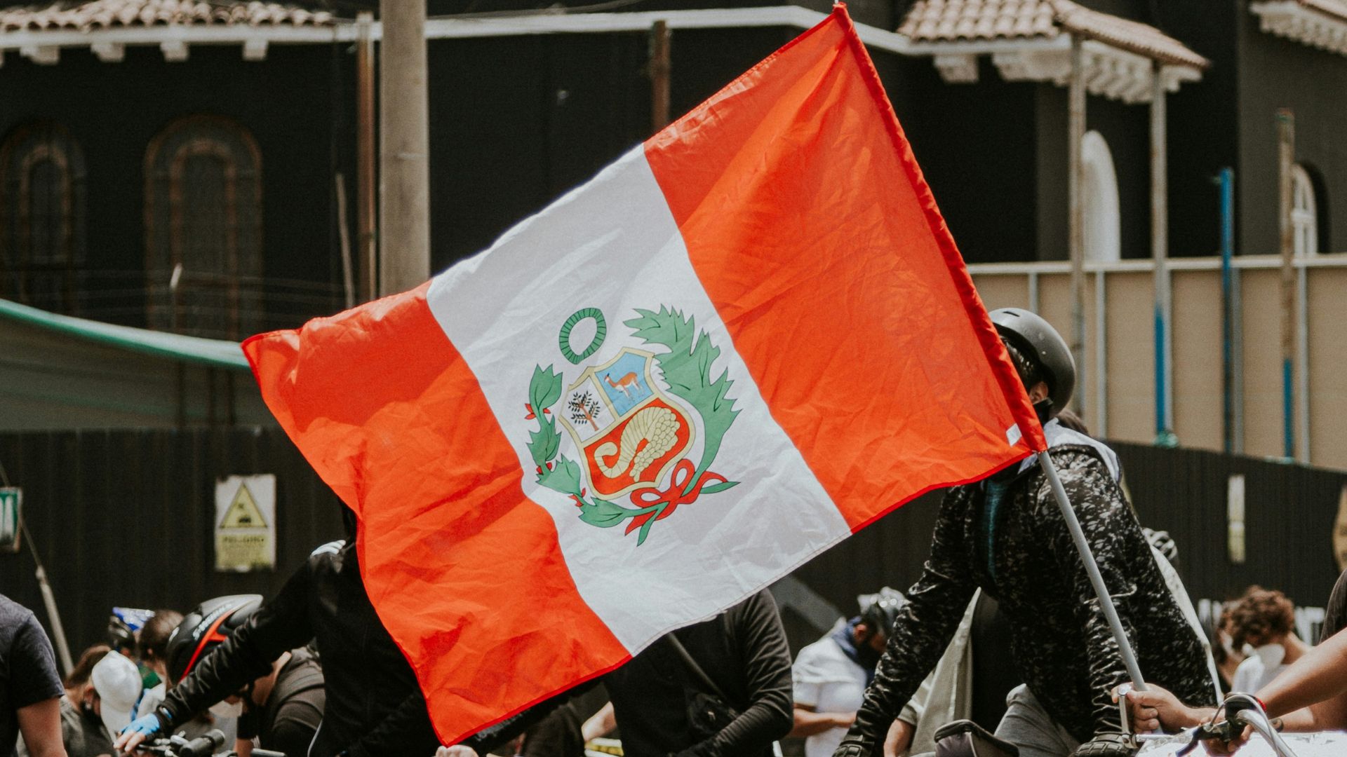 Peru state flag carried by bicycle riders.