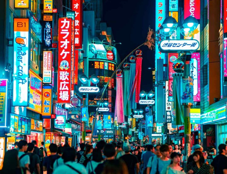Japan's Shibuya at night, with glowing street lights, signages, and crowd