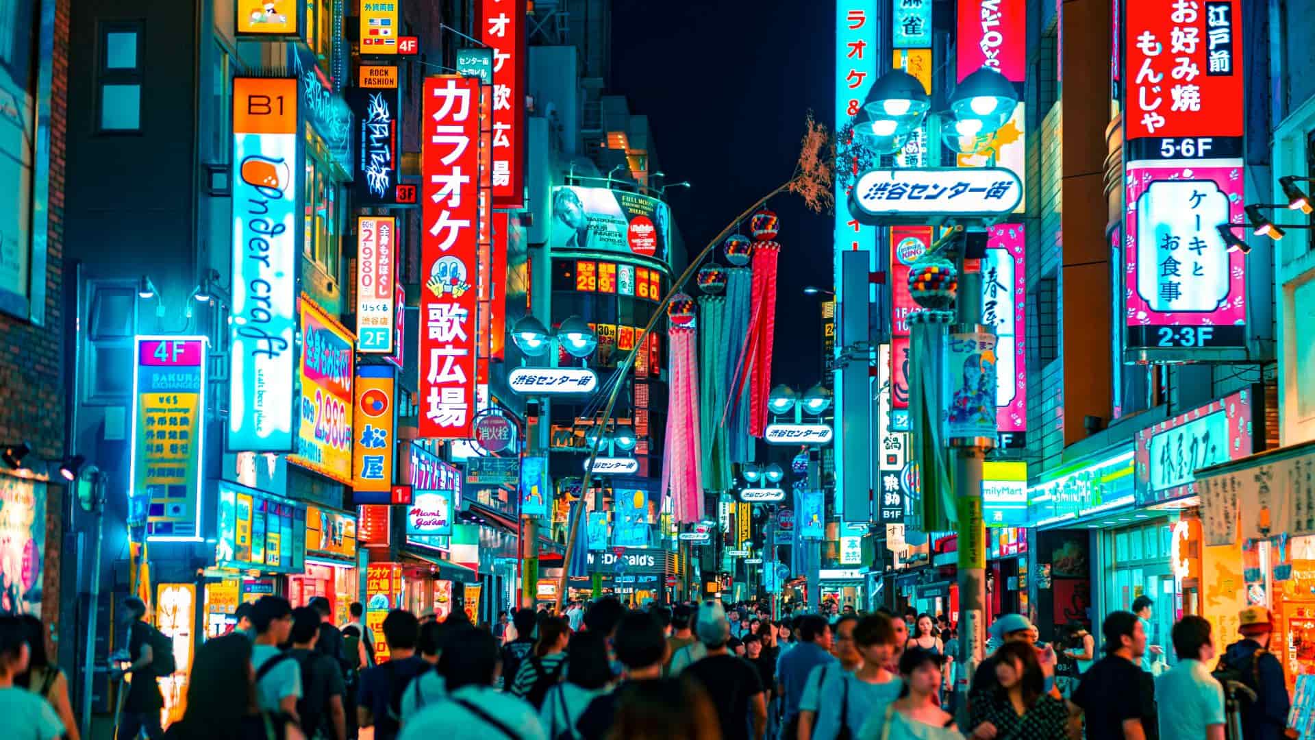 Japan's Shibuya at night, with glowing street lights, signages, and crowd