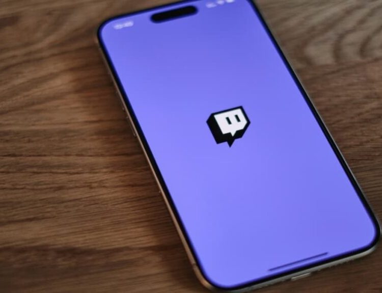 Picture of a smartphone with the Twitch app opened, lying on a desk.
